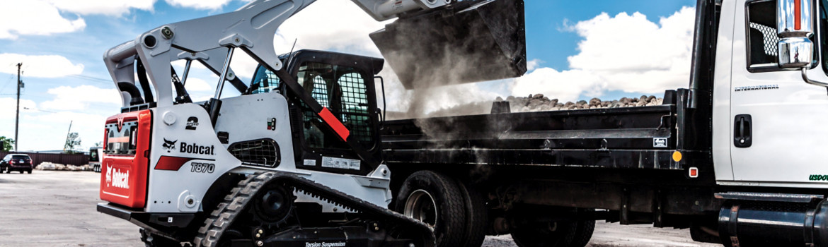 2018 Bobcat T870 dumping rocks into the bed of an International® truck